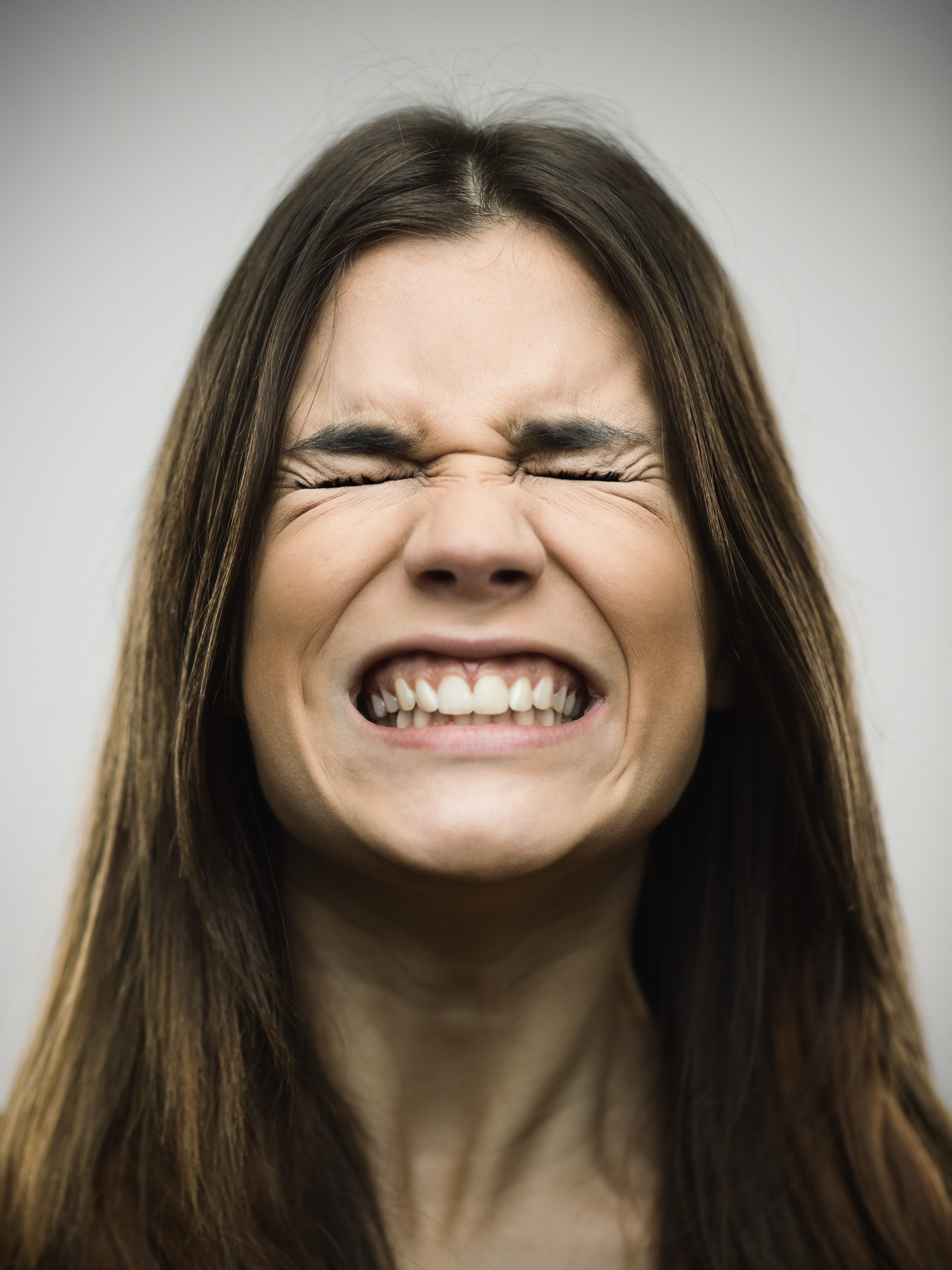 Woman clenching teeth in pain — bruxism TMJ